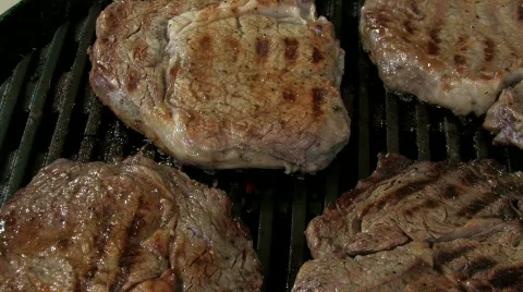 Grilling rib eye steak close up Stock Footage