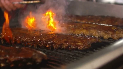 Grilling ribs on an open flame restaurant american business Stock Footage 72708221