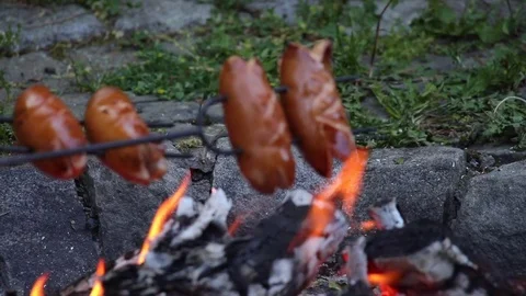 Grilling sausages over a campfire, double slow motion. Detail of sausages. Stock Footage 76563299