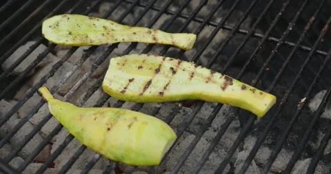 Grilling squash on a bbq grill outside in summer Stock Footage 290490667