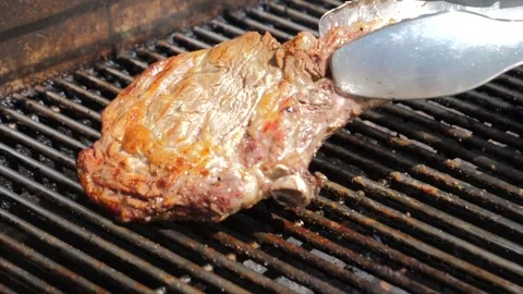 Grilling Steak and Turning It with Tongs Stock Footage 245996345