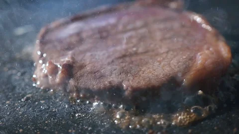 Grilling steaks on BBQ close up. Cooking beef on barbecue using tongs to flip Stock Footage 115778213