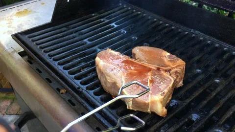 Grilling a T-bone steak Stock Footage 94702370