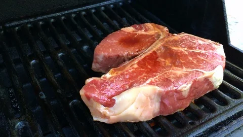 Grilling a T-bone steak Stock Footage 94702565