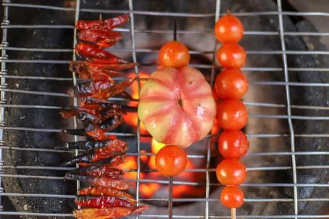 Grilling tomatoes and chilli Stock Photos