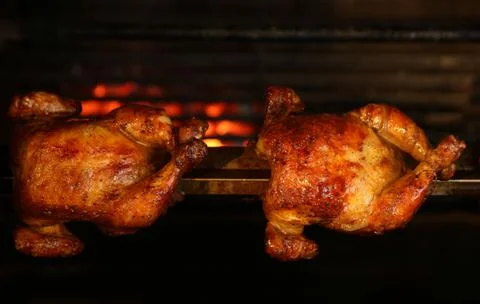 Grilling whole chickens in rotisserie machine, closeup Stock Photos