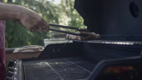 Grillmaster dad puts chicken on the rack Video stock 153310094