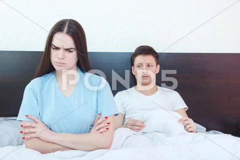 Grim dejected and emotionally hurt woman is angry while man in background st Stock Photos