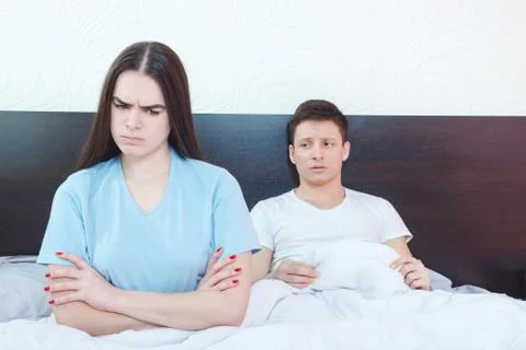 Grim dejected and emotionally hurt  woman is angry while man in background st Stock Photos