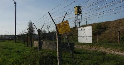 Grim Looking Barbed Wired Fence and a Guard Tower With a Yellow Prohibition Stock Footage 53092043