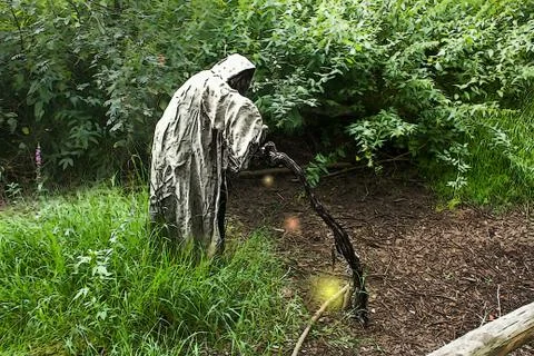 A grim reaper / ghost / witch in a long hood  in the middle of the woods Stock Photos