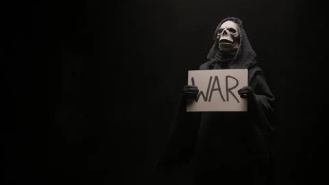 Grim reaper with a serious skeleton face holding a War sign in his hands, on a Stock Footage 255478061