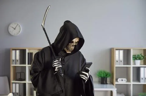 Grim Reaper Using Phone For Online Activity In Office Stockfoto's