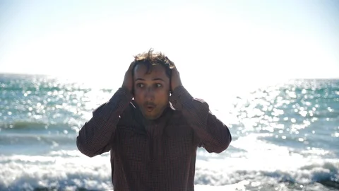 Grimace of wild joy on a man's face against the background of the sea Stock Footage 97068992