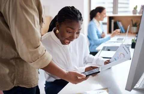 A grin that could split my face. a young businesswoman discussing paperwork with Stock Photos