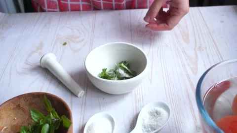 Grind basil leaves with salt to make a pesto sauce. Home cooking Stock Footage 153104753