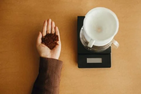 Grind coffee close up in hands on background of glass kettle with pour over o Stock Photos