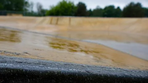 Grind rail edge covered in raindrops in skatepark Stock Photos