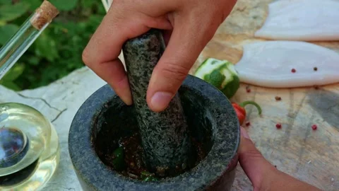 Grind the spices with a stone mortar. Stock Footage 146800318
