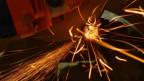 Grinder cuts a piece of pipe. Bright glowing sparks fly around. Sparks Close Up Stock Footage 121506599