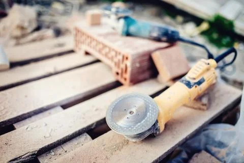 Grinder, metal angle grinder in construction site used for cutting bricks Stock Photos
