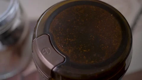 Grinder moves quickly while beans become fresh coffee powder Stock Footage 344171282