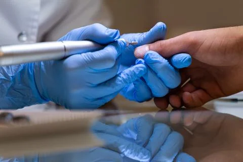 Grinding and processing of nails in the salon close-up, master pedicure Stock Photos