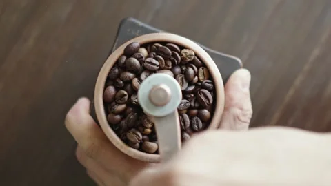 Grinding of aromatic coffee beans with a manual coffee grinder Video stock 312134145