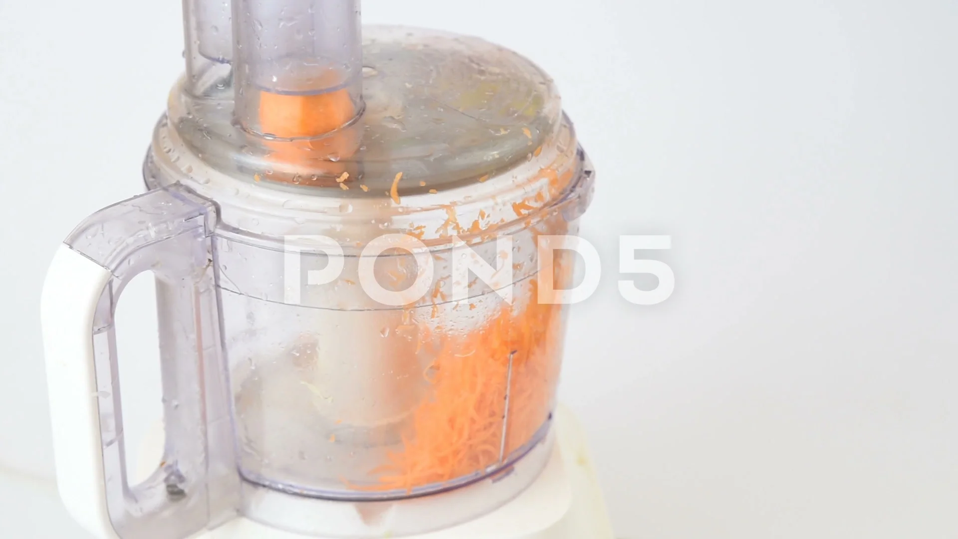 Grinding Carrots Using An Electric Food Processor Stock Photo