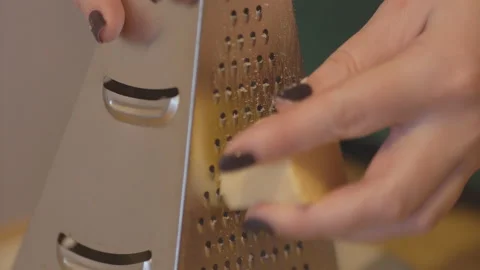 Grinding cheese on a grater in motion Video stock 85465492