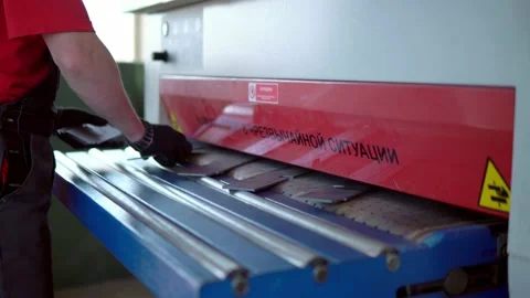 Grinding a CNC machine. The production worker gives parts to the converge of the Stock Footage 201821409