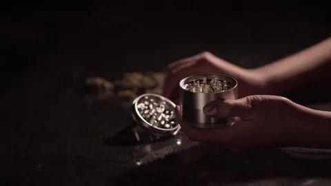 Grinding cones of marijuana with a grinder close-up. Weed buds and grinder in 스톡 동영상 83048189