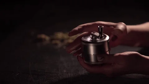 Grinding cones of marijuana with a grinder close-up. Weed buds and grinder in 스톡 동영상 83048321