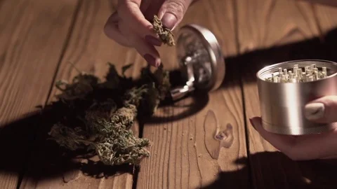 Grinding cones of marijuana with a grinder close-up. Weed buds and grinder in 스톡 동영상 83050320