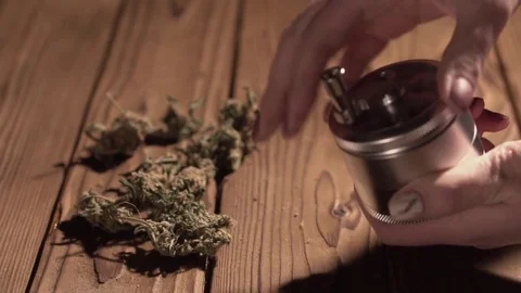 Grinding cones of marijuana with a grinder close-up. Weed buds and grinder in 스톡 동영상 83050350