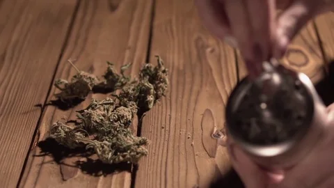 Grinding cones of marijuana with a grinder close-up. Weed buds and grinder in 스톡 동영상 83050477