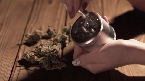 Grinding cones of marijuana with a grinder close-up. Weed buds and grinder in 스톡 동영상 83050511
