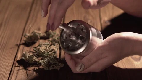 Grinding cones of marijuana with a grinder close-up. Weed buds and grinder in 스톡 동영상 83050554