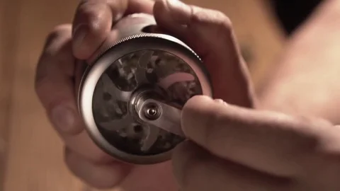 Grinding cones of marijuana with a grinder close-up. Weed buds and grinder in 스톡 동영상 83050576