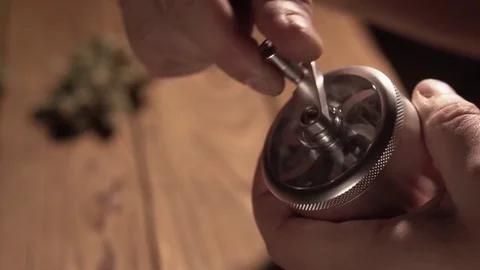 Grinding cones of marijuana with a grinder close-up. Weed buds and grinder in 스톡 동영상 83050634