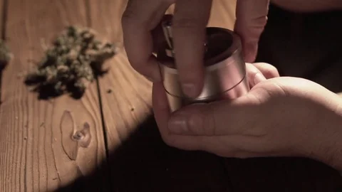 Grinding cones of marijuana with a grinder close-up. Weed buds and grinder in 스톡 동영상 83050700