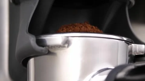 Grinding fresh coffee beans with a grinder or portafilter to make hot Arabica Stock Footage 256498462