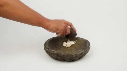 Grinding Garlic Using Traditional Stone Mortar and Pestle Stock Footage 327851184