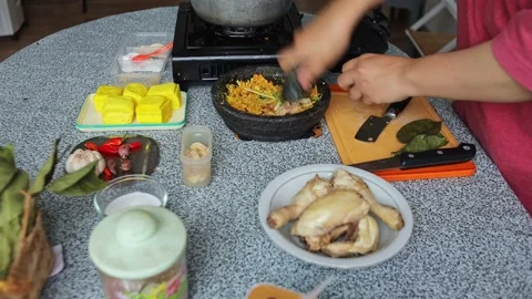 Grinding herbs into spice paste using traditional mortar and pestle for cooking Stock Footage 344910797