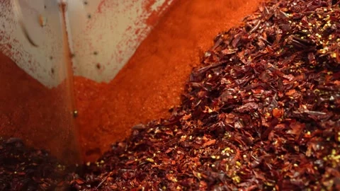 Grinding hot red pepper creating spicy powder and dry flakes for cooking Stock Footage 333521369