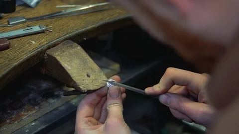 Grinding irregularities of the surface of a silver ring by means of an emery Stock Footage 73554567