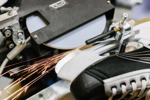 Grinding machine creating bright sparks while sharpening the metal blade of a Stock Photos