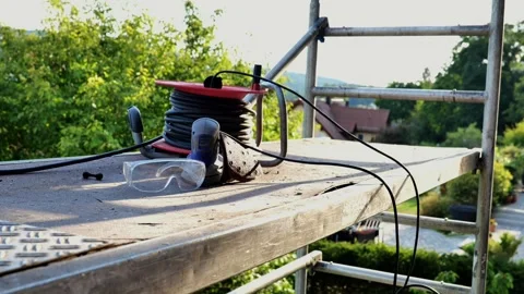 Grinding machine, wires, construction glasses on scaffolding Stock Footage 317512329