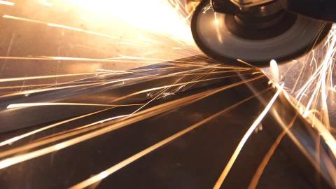 Grinding metal by machine in workshop. Stock Photos