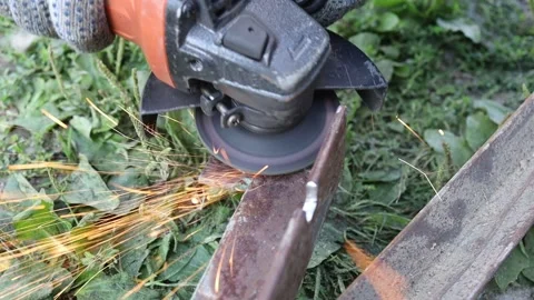 Grinding metal with a tool in an outdoor setting Stock Footage 344180613